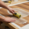someone using a roller to apply adhesive to a laminate sheet