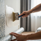someone using a brush to apply glue to a wall surface when installing a wall paper
