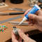  someone using a small super glue with a nozzle