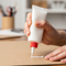 someone using a squeeze tube of glue
