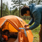 someone using duck tape to repair a tent