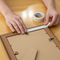 someone using double sided tape on the back of picture frame