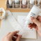 A person carefully applies Glues Australia's non-staining glue to a delicate piece of lace for a handmade wedding invitation, showcasing a clean and precise application for all your crafting and DIY projects