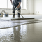 someone applying a self levelling cementitious product on the floor