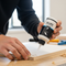 A close-up lifestyle image showing a person applying Glues Australia Edge Sealing product to a wooden surface in a clean workshop, perfect for DIY and professional use