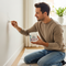 A clean, modern lifestyle image showing a person easily and effectively patching a hole in a wall, highlighting the simplicity and quality of the Glues Australia Hole Patching product