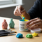 image for Glues Australia's Putty Container, showing a person's hands on a modern wooden desk with organized art supplies